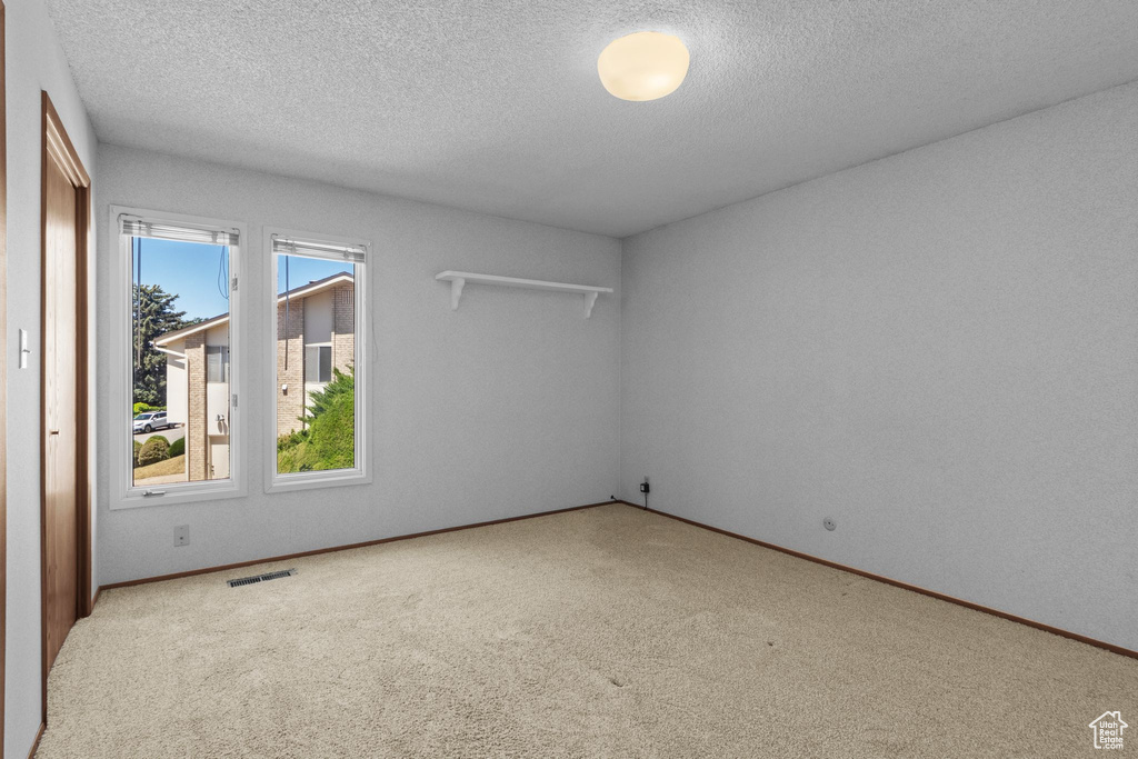 Spare room with a textured ceiling and carpet