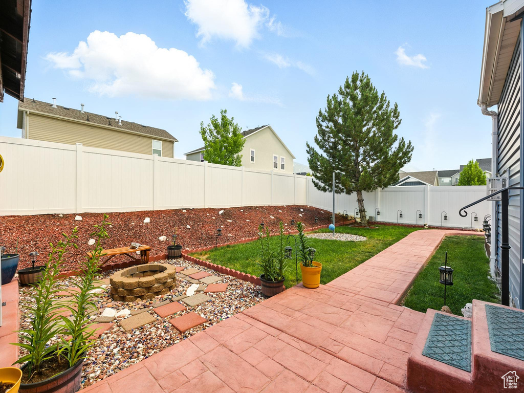 Fenced backyard featuring an outdoor fire pit and a patio area