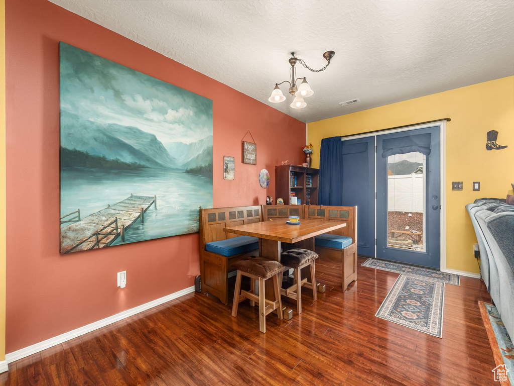 Dining room featuring wood finished floors and a chandelier