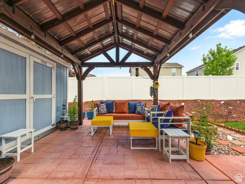 Fenced backyard featuring a gazebo, a patio, and an outdoor hangout area
