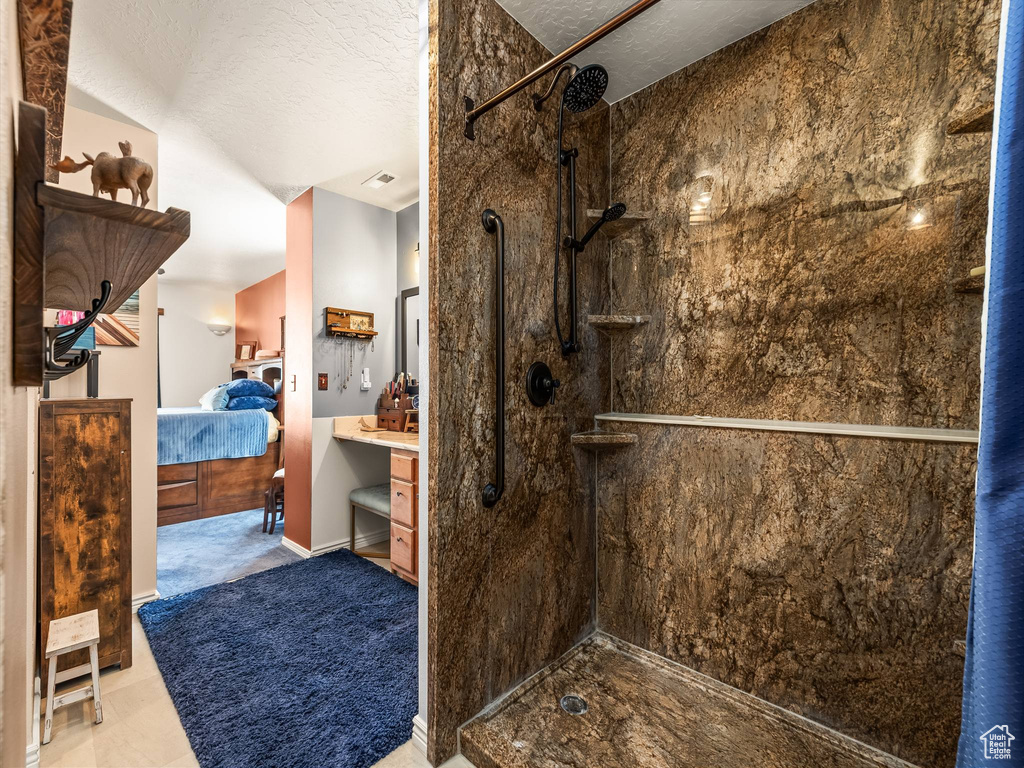 Full bath with ensuite bathroom, a walk in shower, and a textured ceiling