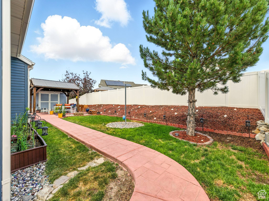 Fenced backyard featuring a vegetable garden and a patio