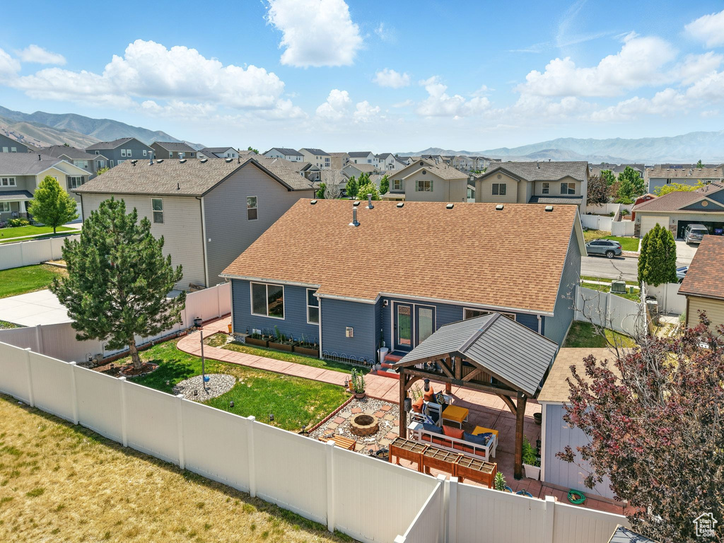 Back of property featuring a gazebo, a residential view, a mountain view, and a fire pit