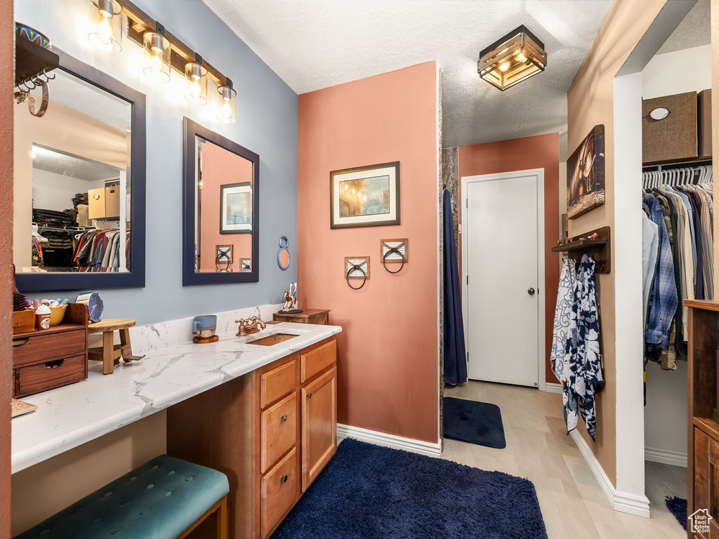 Full bathroom featuring vanity and a spacious closet