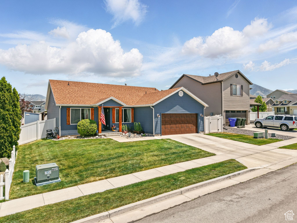 View of front of home with driveway, a garage, and a gate