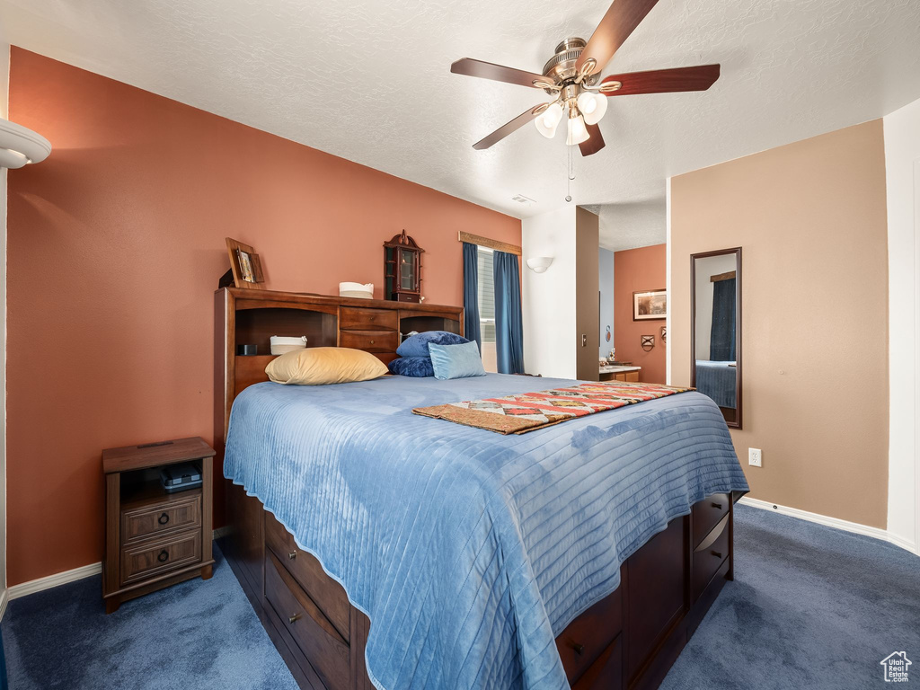 Bedroom with dark carpet and ceiling fan