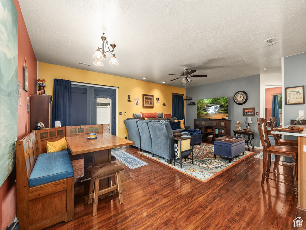 Dining area with wood finished floors, a ceiling fan, and a textured ceiling