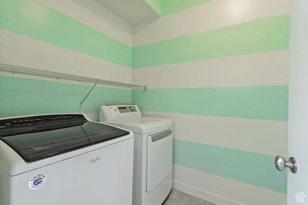 Laundry room featuring washer and dryer and light tile patterned floors