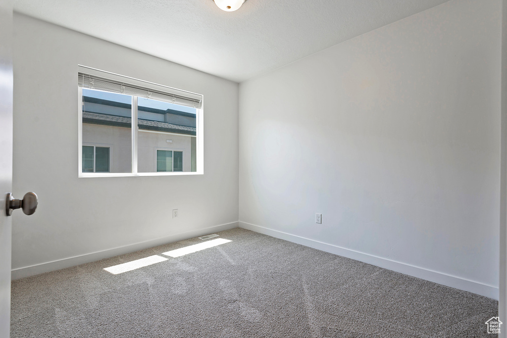 Empty room with baseboards and carpet
