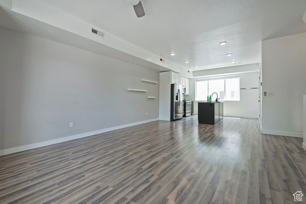 Unfurnished living room featuring dark wood finished floors, recessed lighting, and a ceiling fan