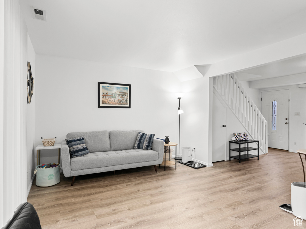 Living area with stairway and light wood-style flooring