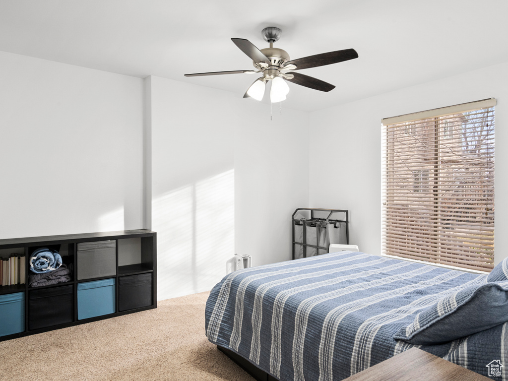 Carpeted bedroom featuring ceiling fan