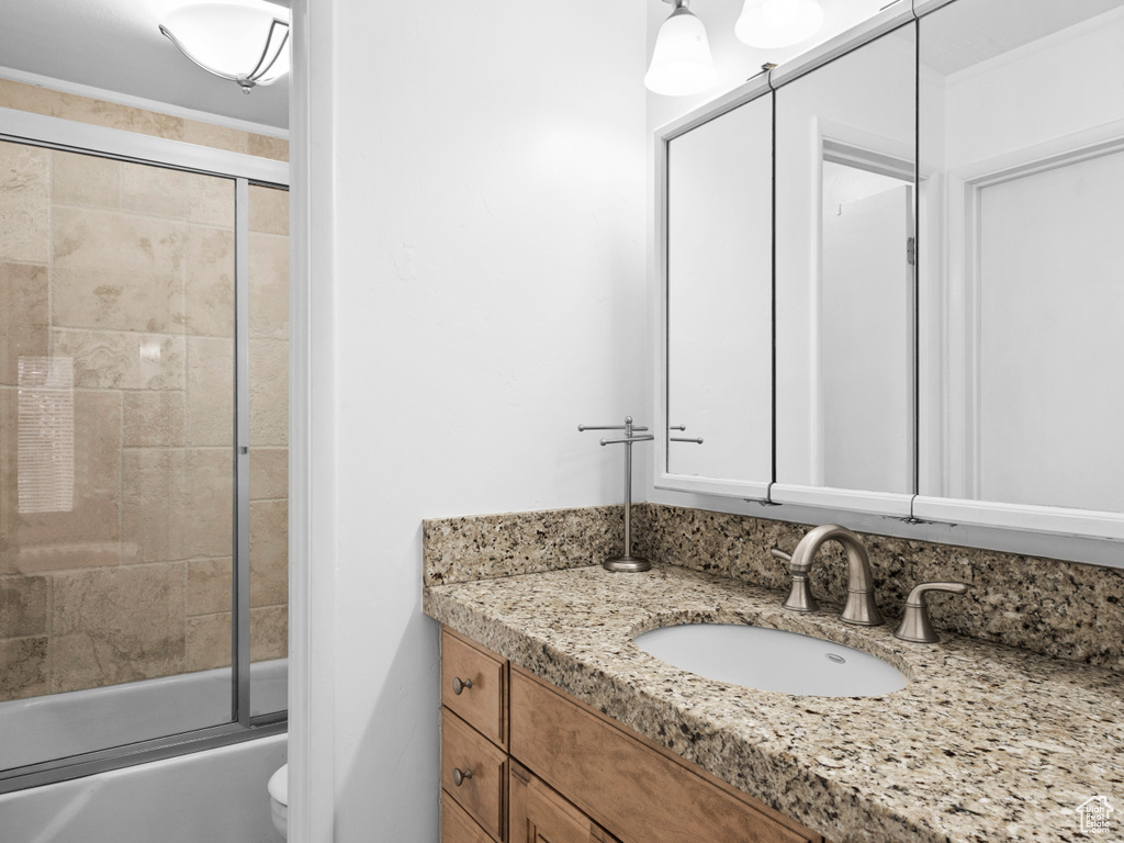 Bathroom featuring vanity and combined bath / shower with glass door