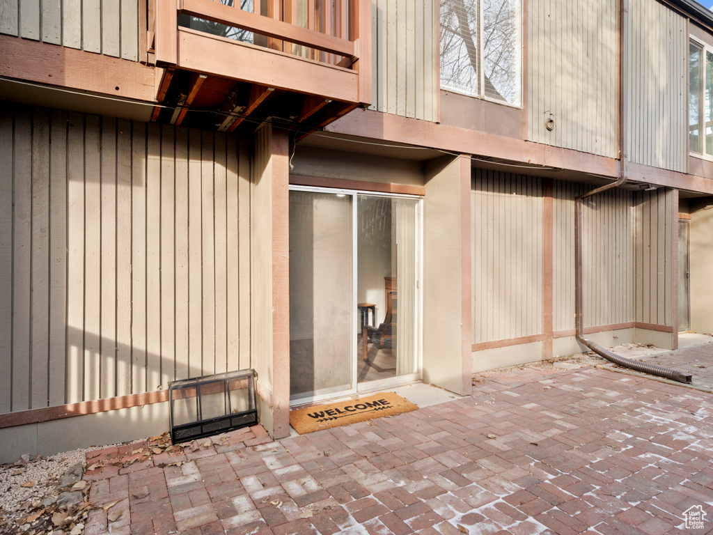 View of exterior entry with a balcony and a patio area