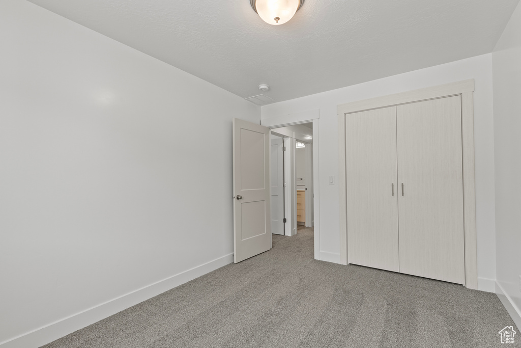 Unfurnished bedroom featuring carpet flooring and a closet