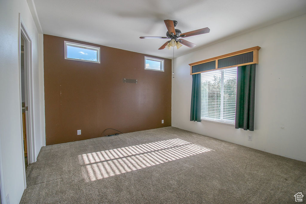 Spare room with carpet floors and a ceiling fan