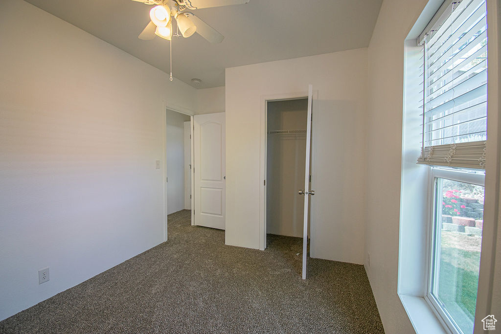 Unfurnished bedroom with carpet, a closet, and ceiling fan
