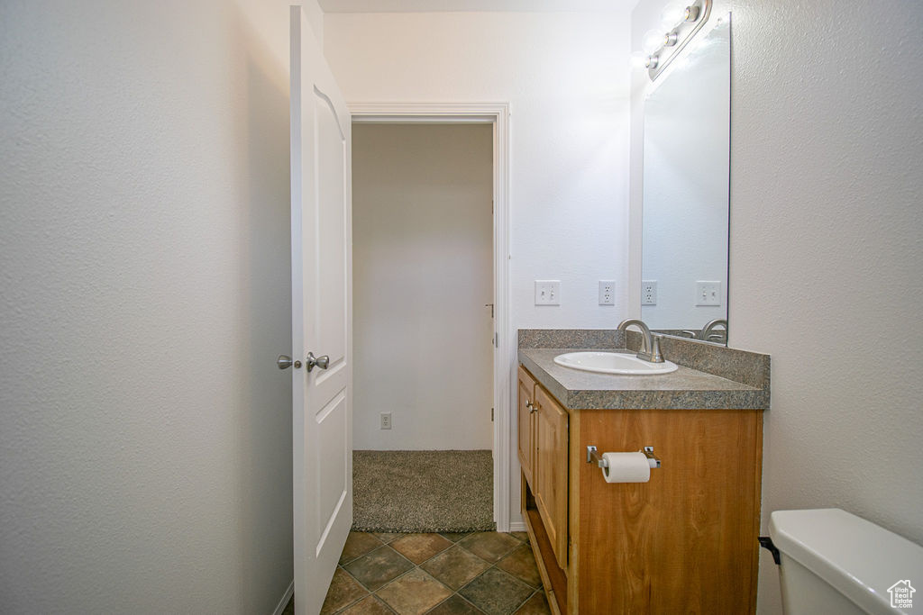 Half bathroom with vanity and toilet