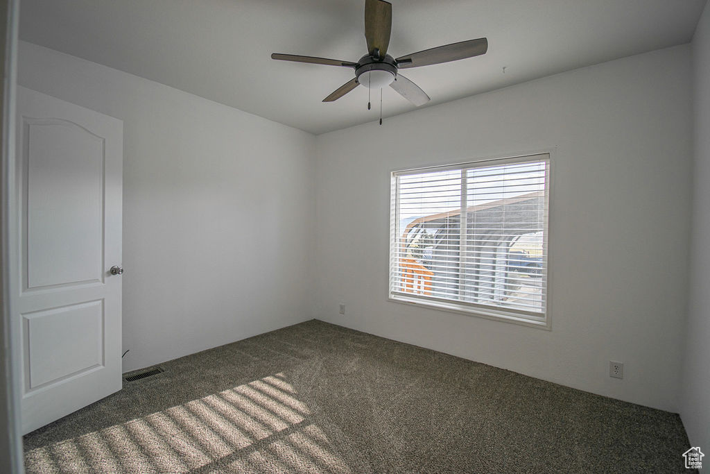 Empty room with carpet floors and ceiling fan