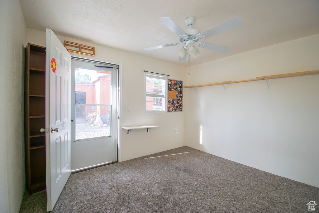 Carpeted empty room featuring a ceiling fan