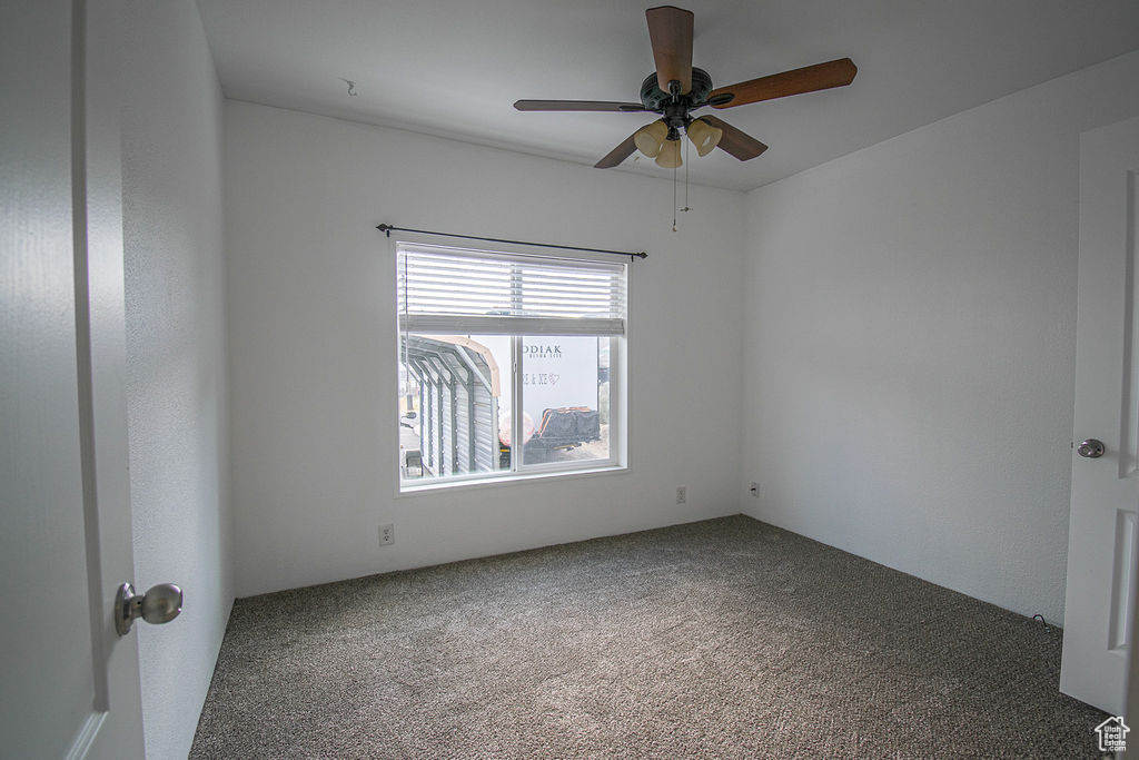 Unfurnished room with ceiling fan and carpet flooring