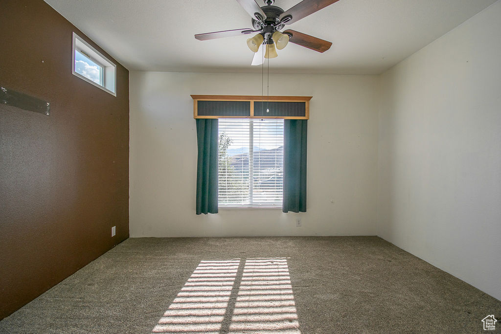 Empty room featuring carpet and a ceiling fan