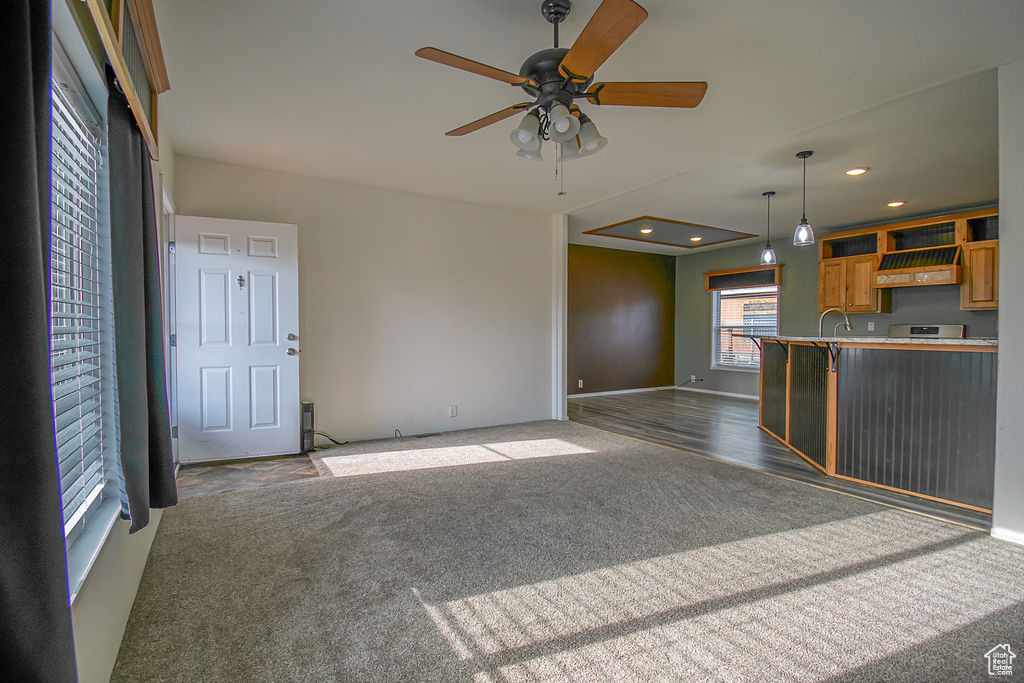 Unfurnished living room featuring ceiling fan, carpet flooring, and recessed lighting
