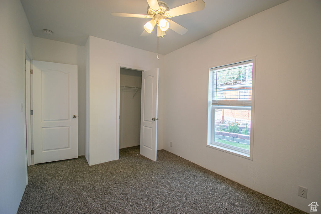 Unfurnished bedroom featuring carpet flooring, a closet, and a ceiling fan