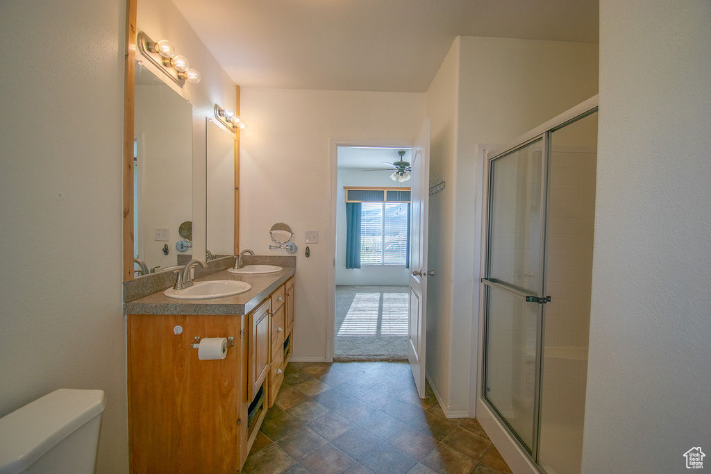 Full bathroom featuring double vanity and a shower with door
