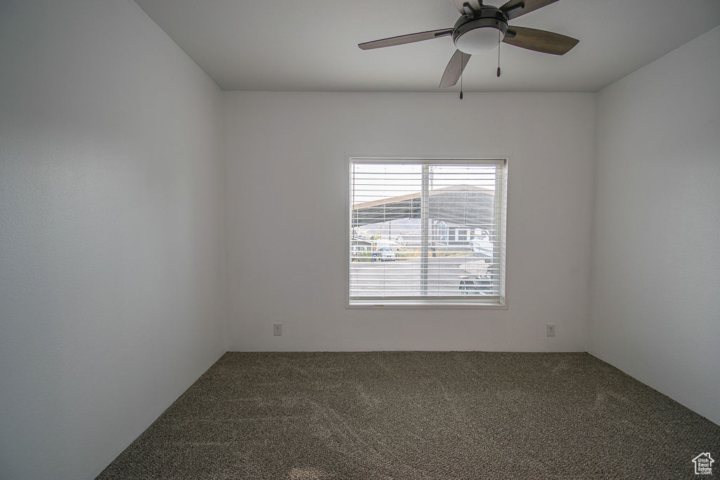 Empty room with carpet floors and ceiling fan