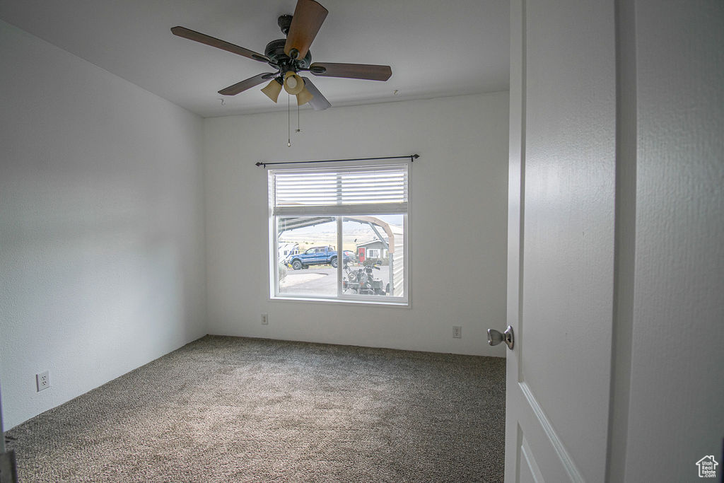 Carpeted empty room with a ceiling fan