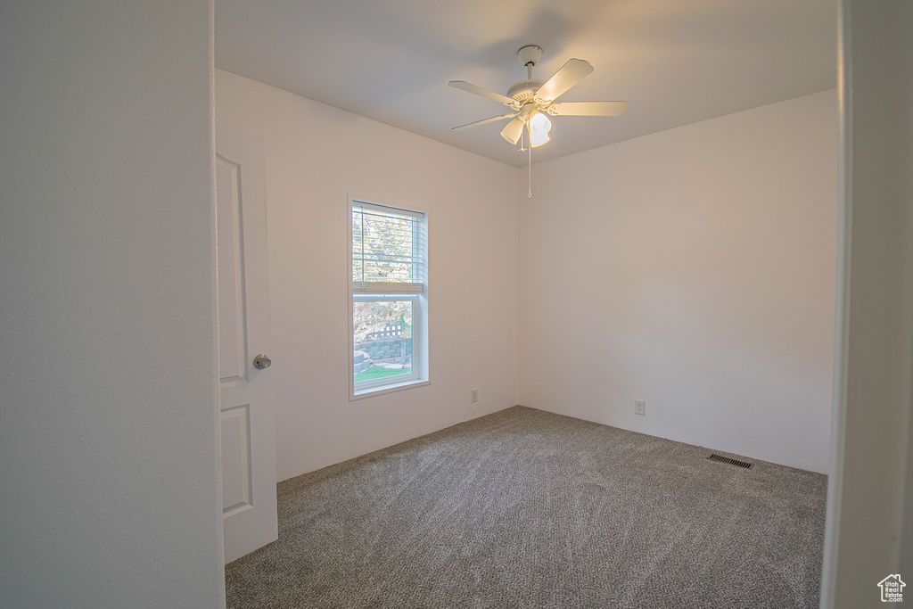 Spare room featuring carpet floors and a ceiling fan