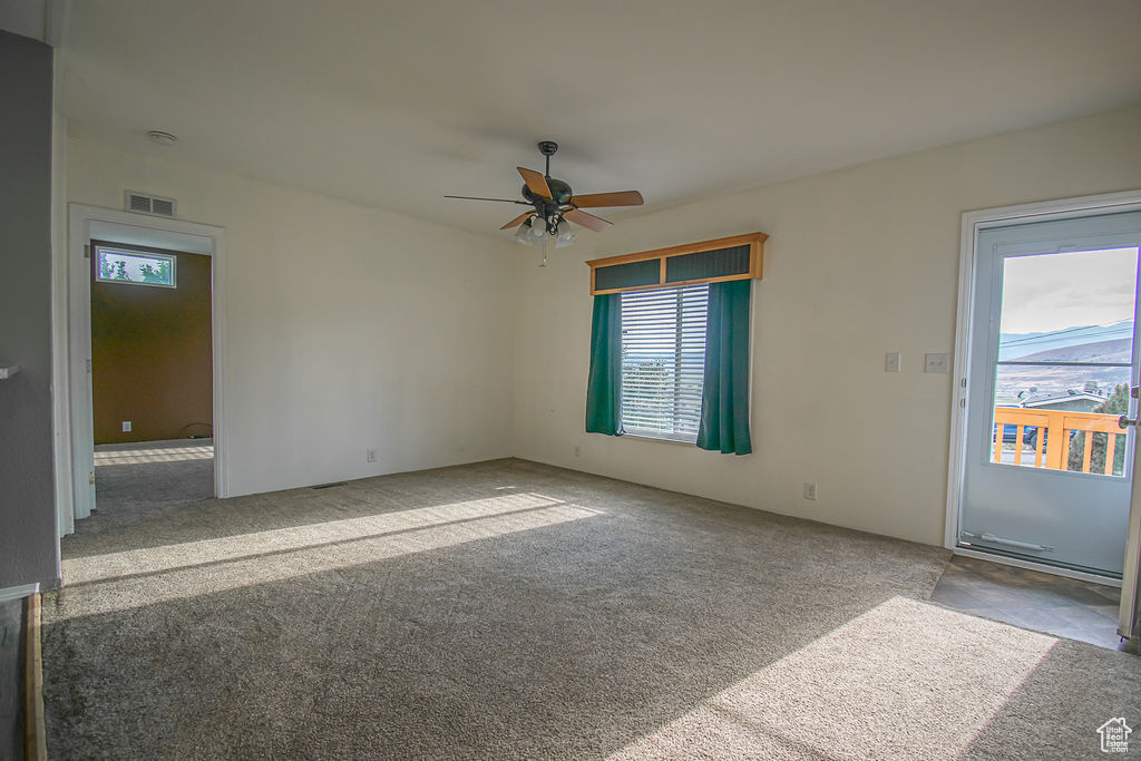 Spare room featuring carpet flooring and a ceiling fan