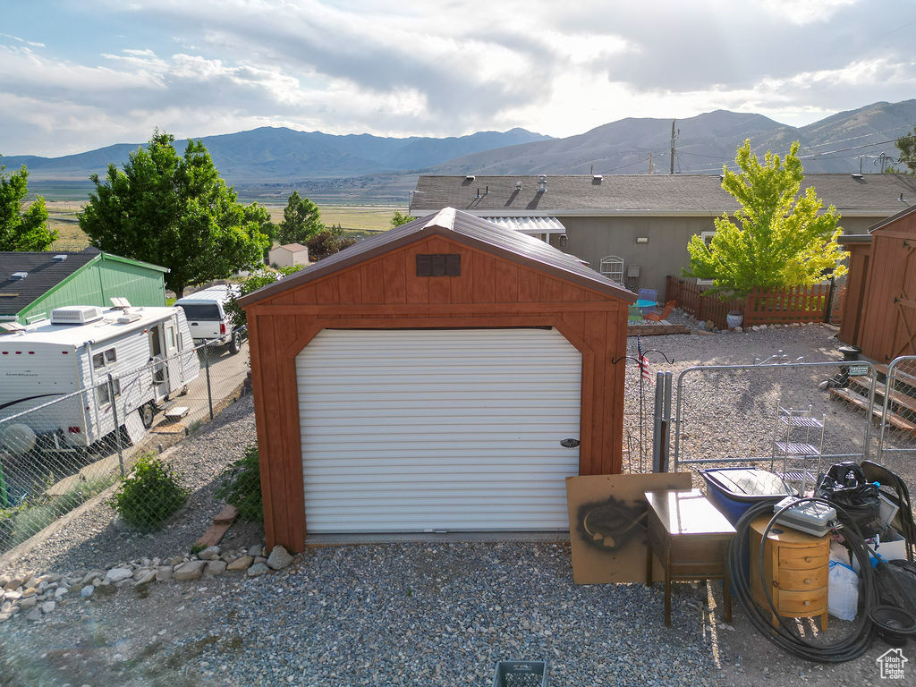 Detached garage featuring a mountain view and gravel driveway