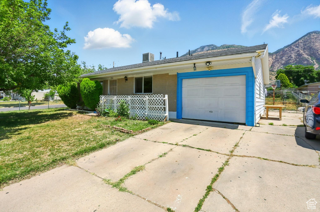 Single story home with driveway, covered porch, a garage, and a mountain view