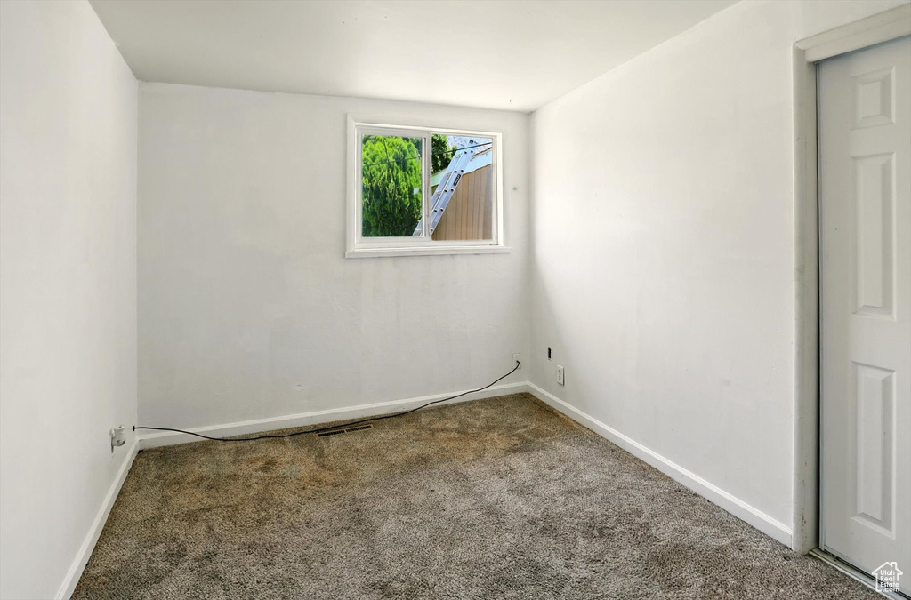 Carpeted spare room with baseboards