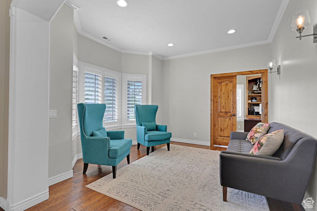 Sitting room with hardwood / wood-style flooring, ornamental molding, and recessed lighting