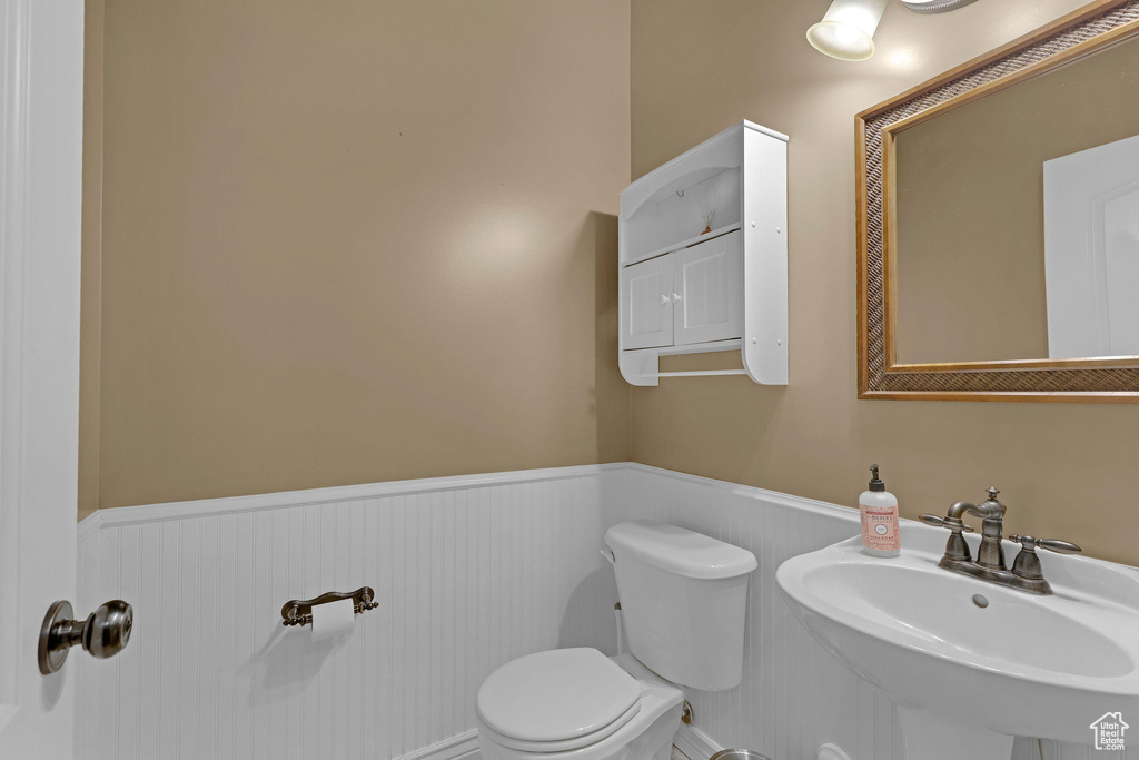 Half bathroom with a wainscoted wall and toilet