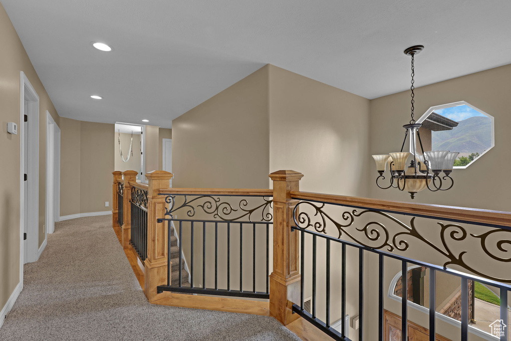 Hall with a chandelier, an upstairs landing, carpet flooring, and recessed lighting