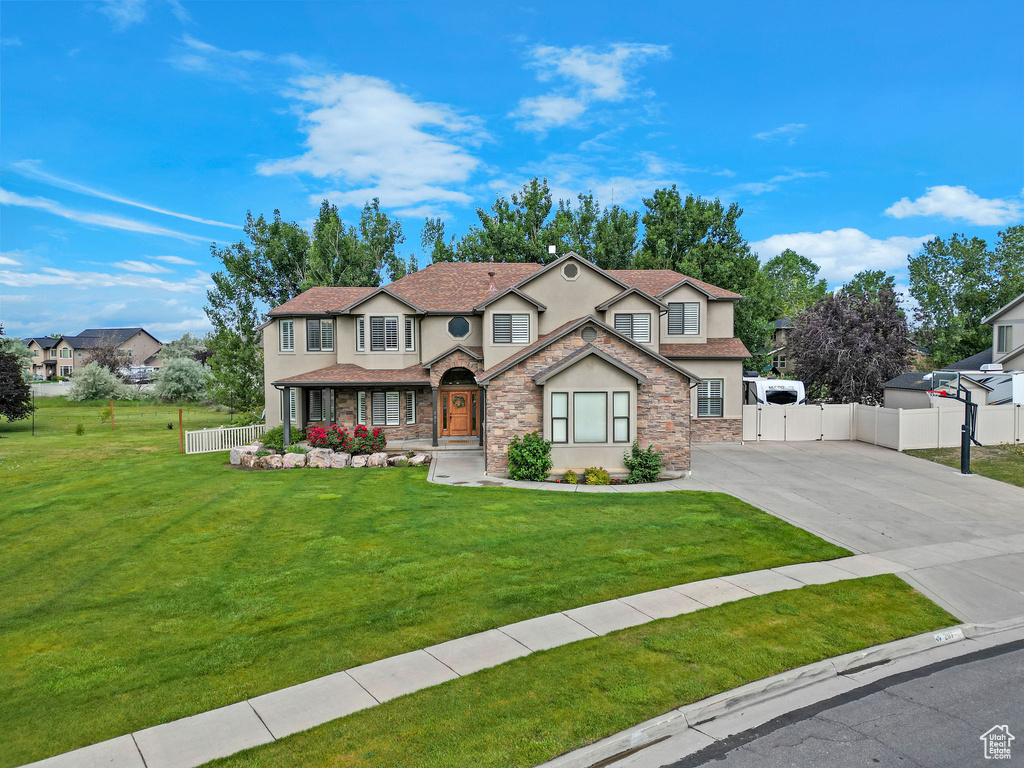 Traditional home with stucco siding, concrete driveway, and a gate