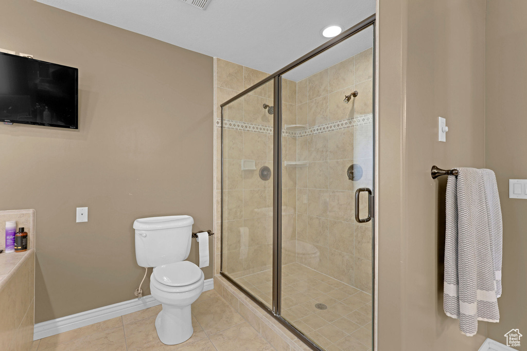 Full bathroom with a shower stall and tile patterned floors