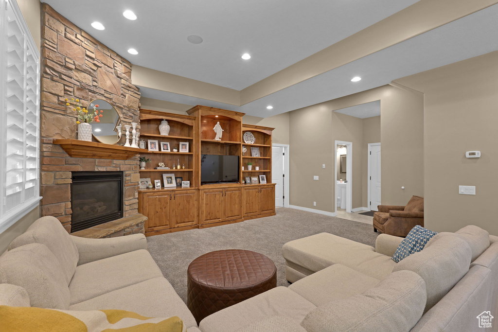 Living room featuring light colored carpet, recessed lighting, and a fireplace