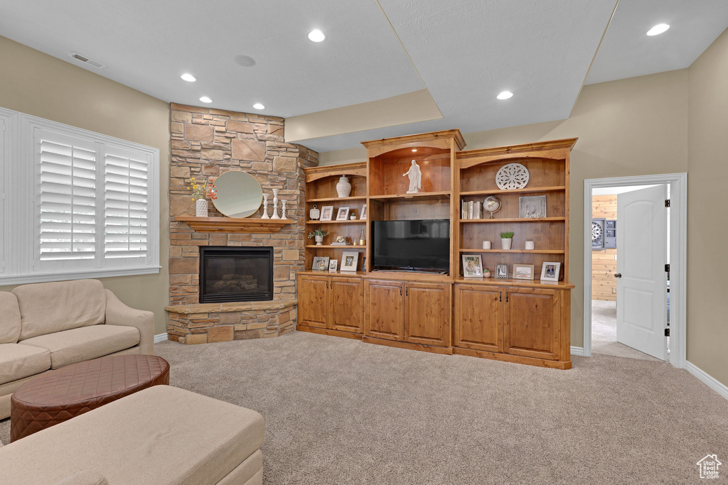 Living area featuring carpet floors, recessed lighting, and a stone fireplace
