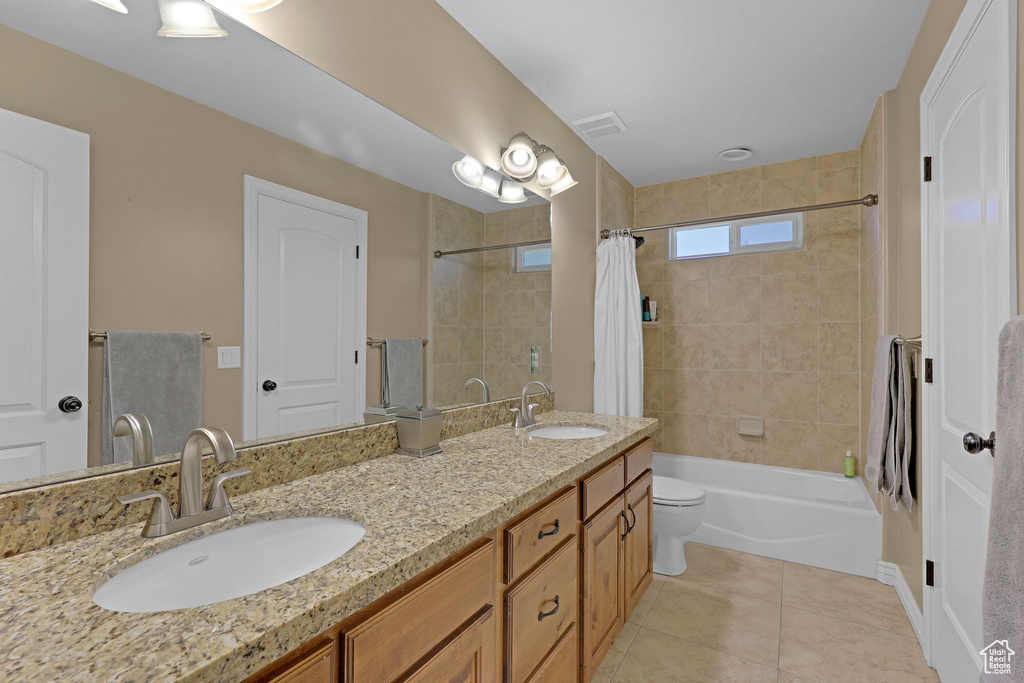 Full bathroom featuring shower / bath combo, double vanity, and tile patterned flooring