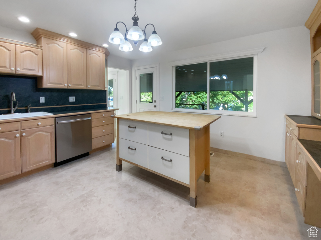 Kitchen with stainless steel dishwasher, light brown cabinetry, butcher block countertops, a chandelier, and decorative light fixtures