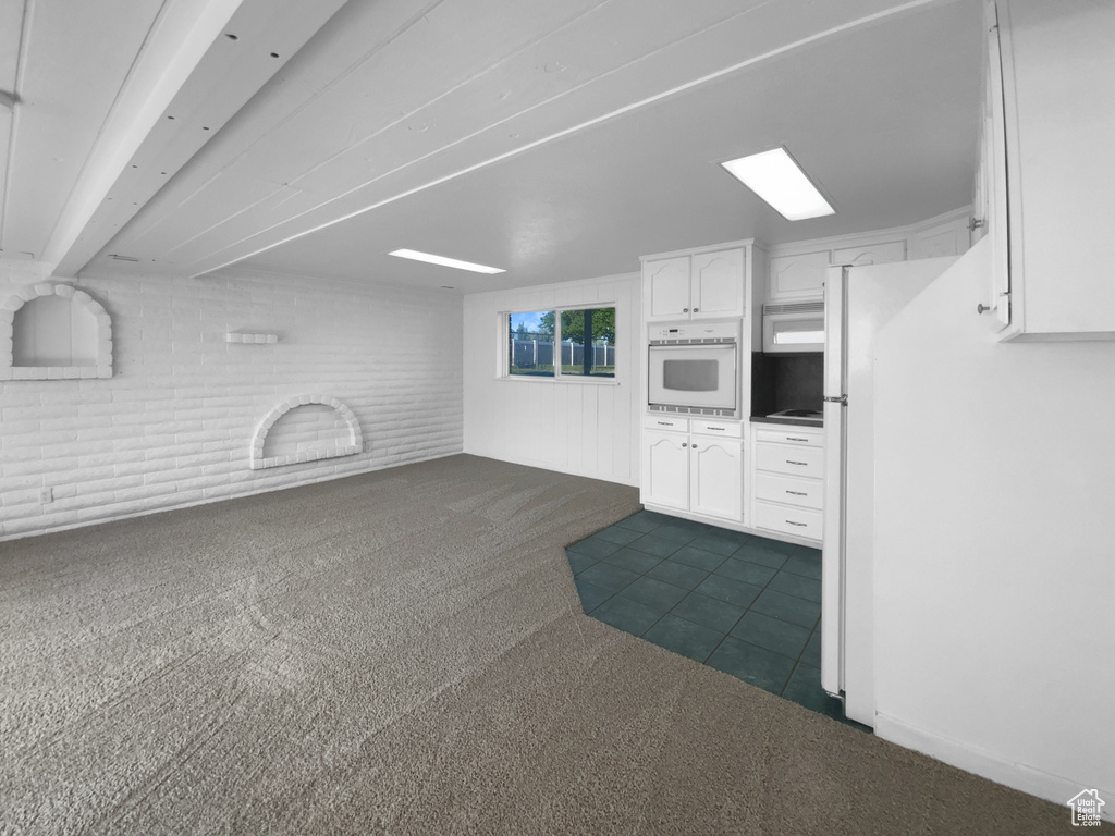 Unfurnished living room featuring dark carpet