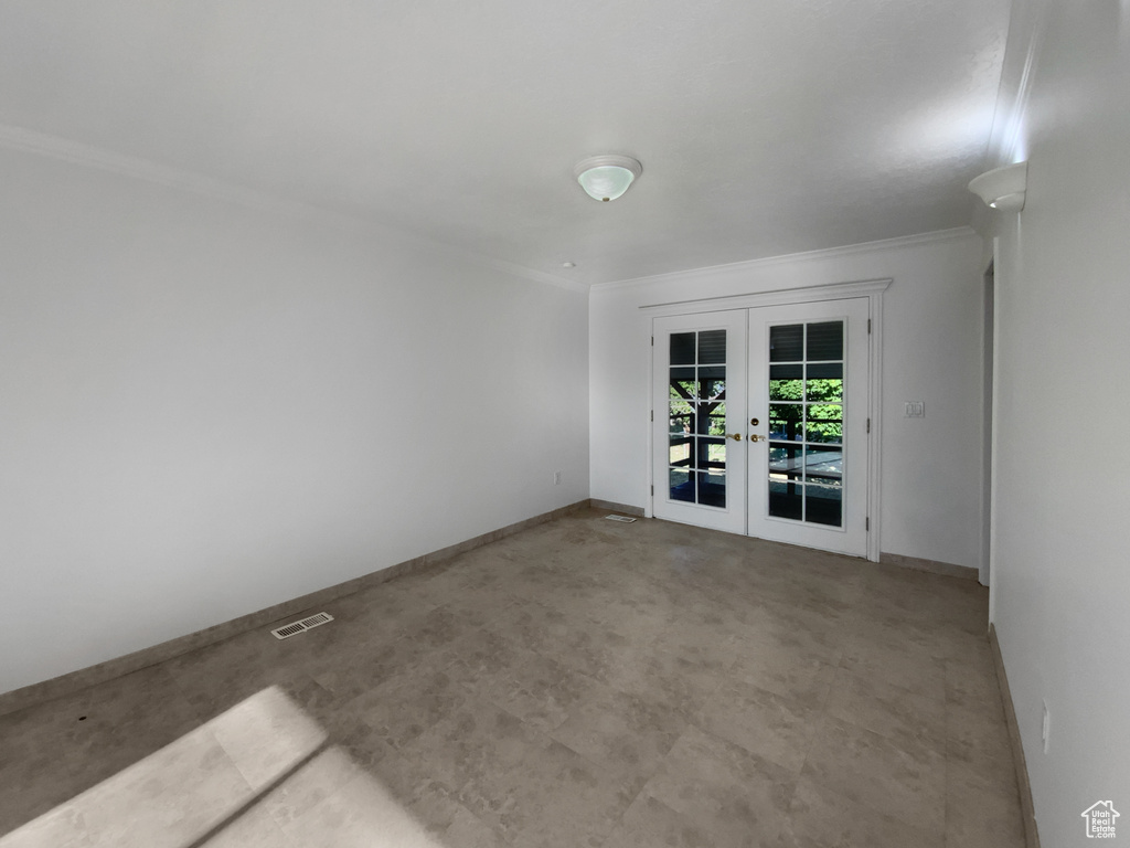Empty room featuring french doors and crown molding