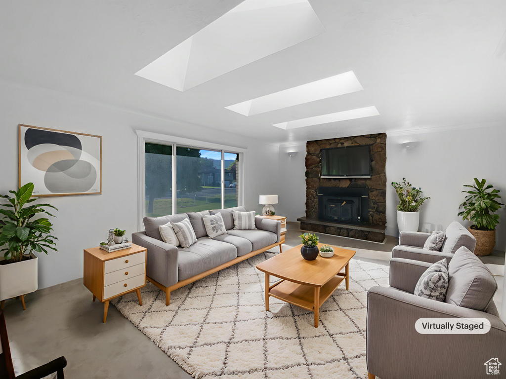 Living area featuring a skylight and a stone fireplace