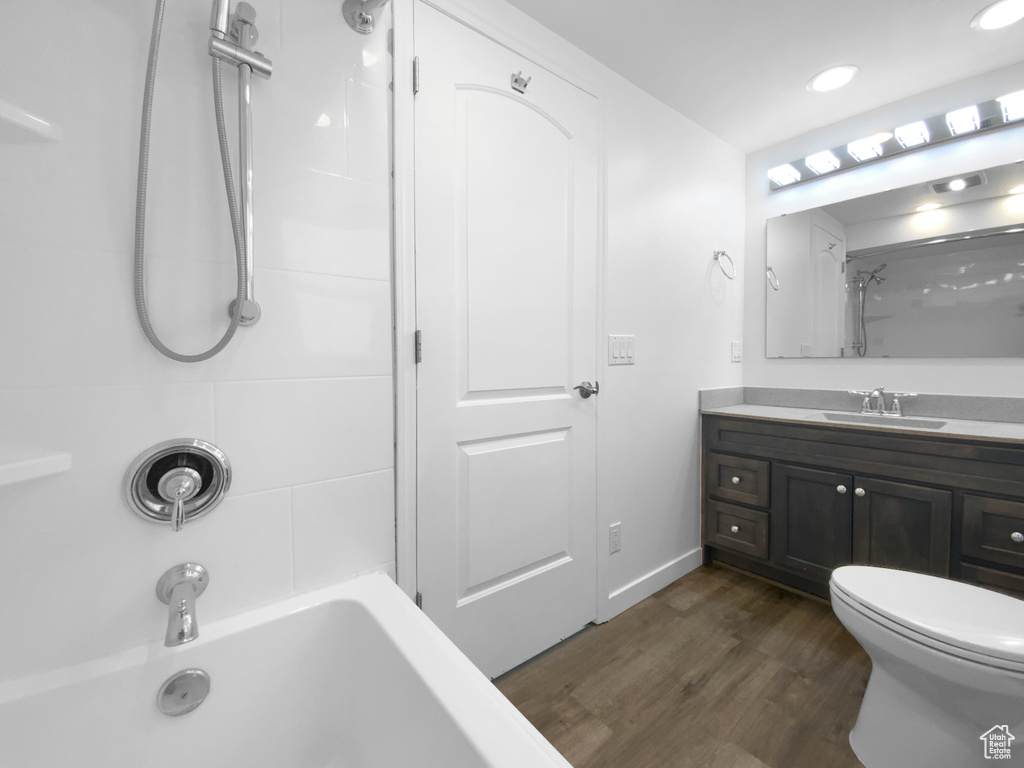 Bathroom featuring wood finished floors, vanity, bathing tub / shower combination, and recessed lighting