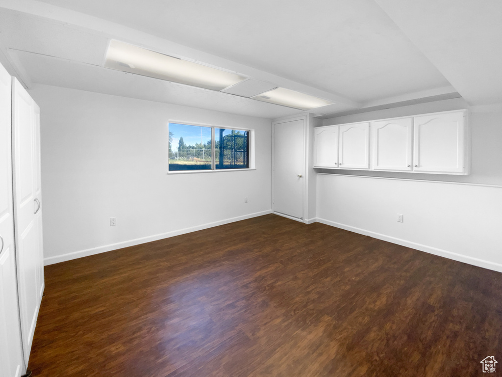 Unfurnished bedroom featuring baseboards and dark wood-style flooring